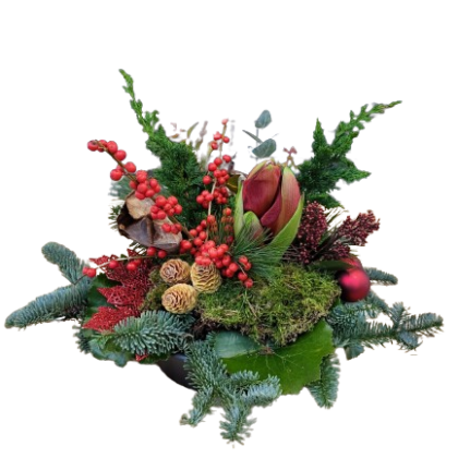 Festive floral centerpiece with red berries, pinecones, evergreens, moss, and a central red flower in a dark bowl.