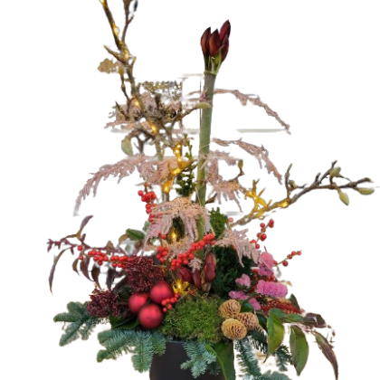 Festive floral arrangement in a black pot with red berries, greenery, and warm string lights.