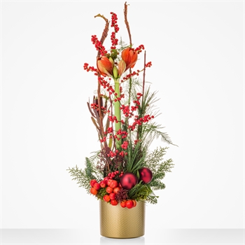 Tall autumn centerpiece with orange tulips, red berries, and greenery in a gold vase.