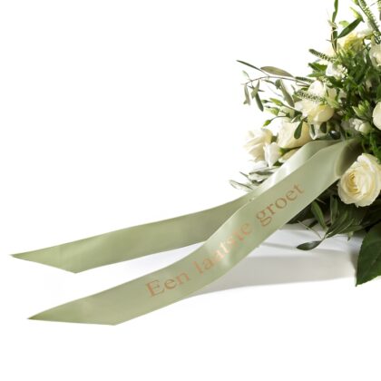 White condolence bouquet with white roses and a pale green ribbon that reads 'Een laatste groet'.